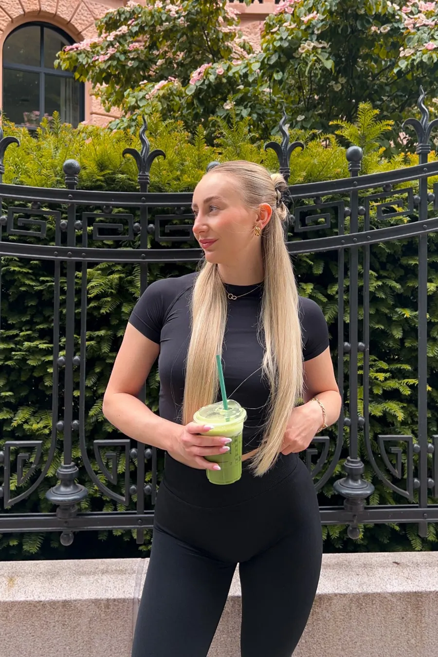 Sophie Schneider im schwarzen Sportoutfit mit grünem Smoothie, Fitness und Food Creatorin